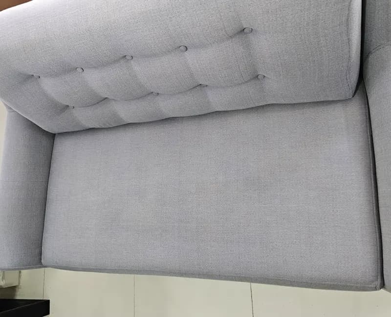 Sofá gris de 2 puestos después del lavado